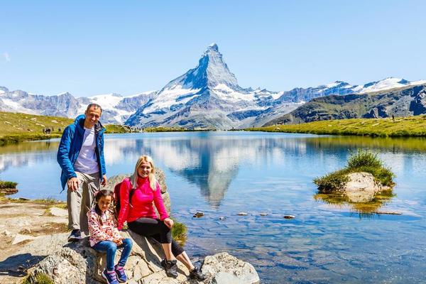 happy-family-with-little-child-doing-trekking-on-switzerland-mountain-in-summer-time-young-people-having-fun in landscape nature concept o travel friendly family